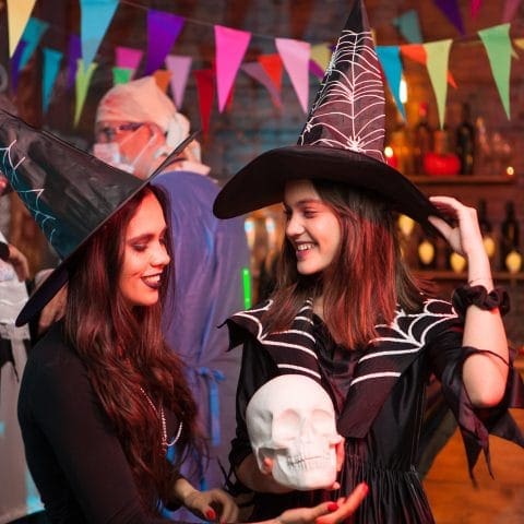 Beautiful witches looking at eachother at halloween celebration